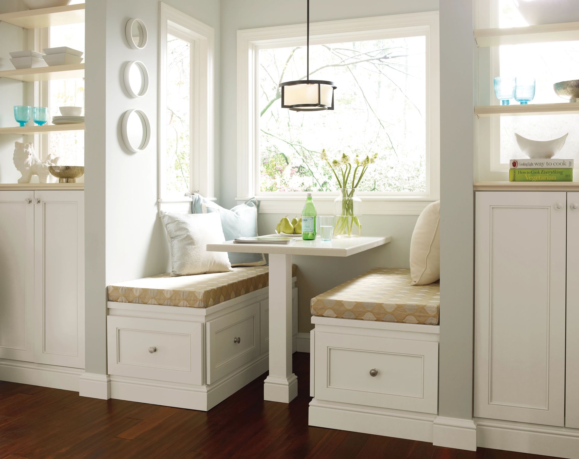 A kitchen with white cabinets and a table in the corner