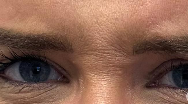 A close up of a woman 's eyes and forehead.
