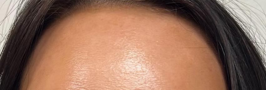 A close up of a woman 's forehead with long hair.