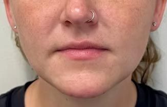 A close up of a woman 's face with a nose ring.