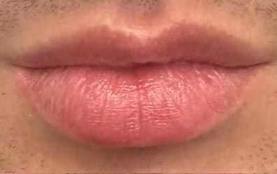 A close up of a man 's lips with a beard.