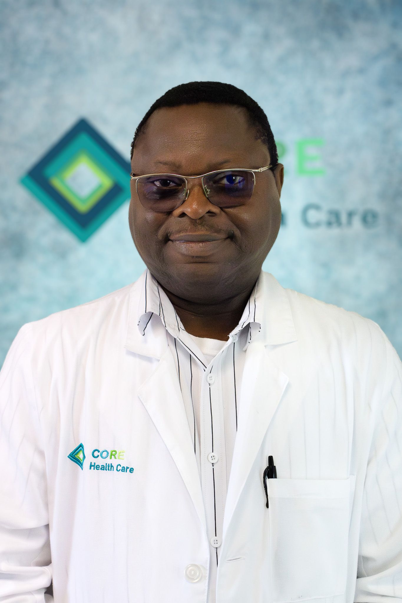 A man wearing glasses and a white lab coat stands in front of a sign that says care