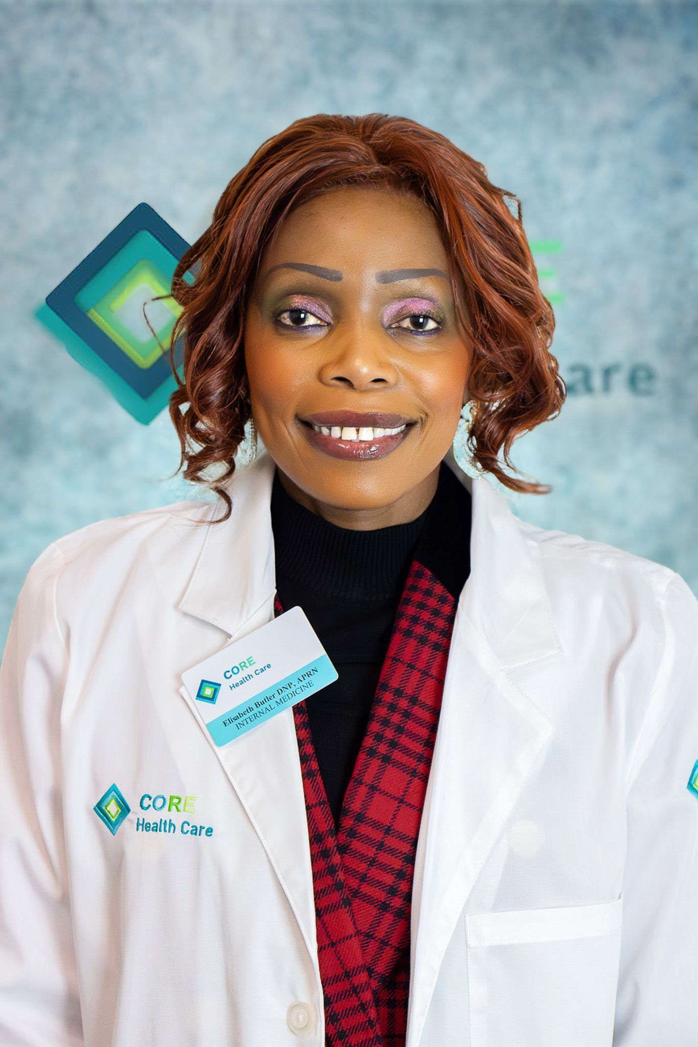 A woman in a white lab coat is smiling for the camera.