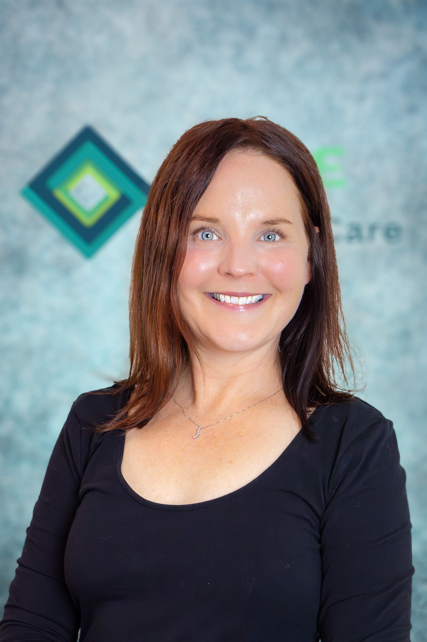 A woman in a black shirt is smiling for the camera.