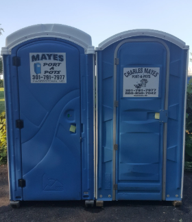 Two blue portable toilets side-by-side with white arched tops. The doors have company logos and phone numbers.