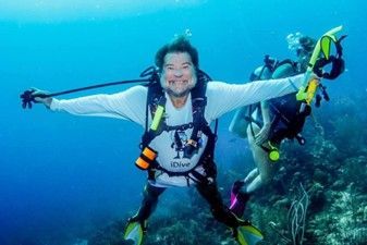 A man is swimming in the ocean with his arms outstretched.