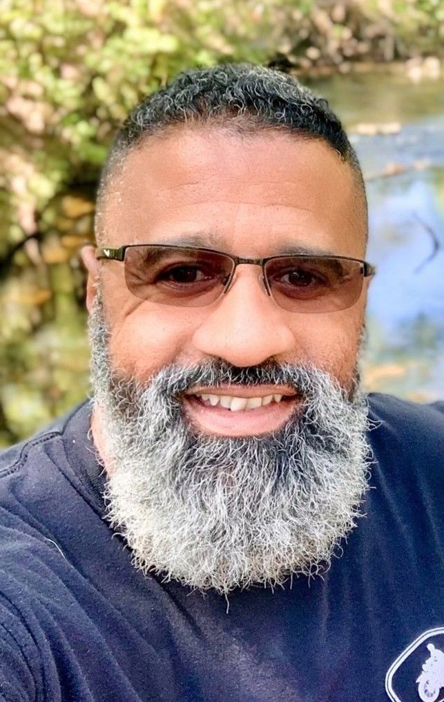 A man with a beard and glasses is smiling for the camera.