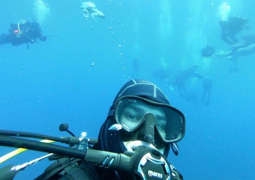 A scuba diver is taking a selfie in the ocean