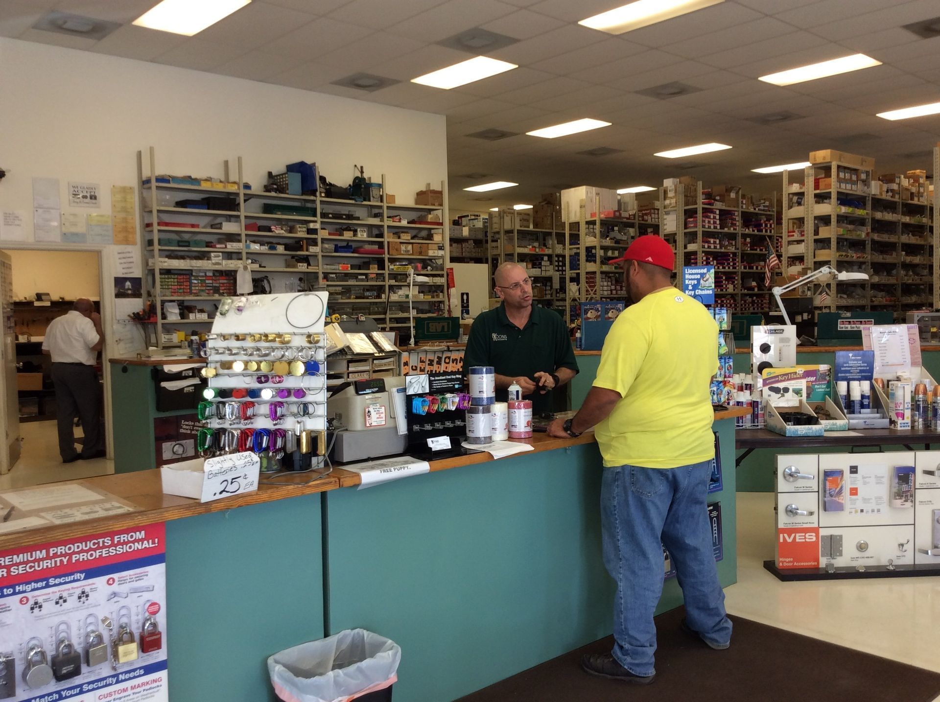 Store checkout counter with two customers and shelves of merchandise in the background