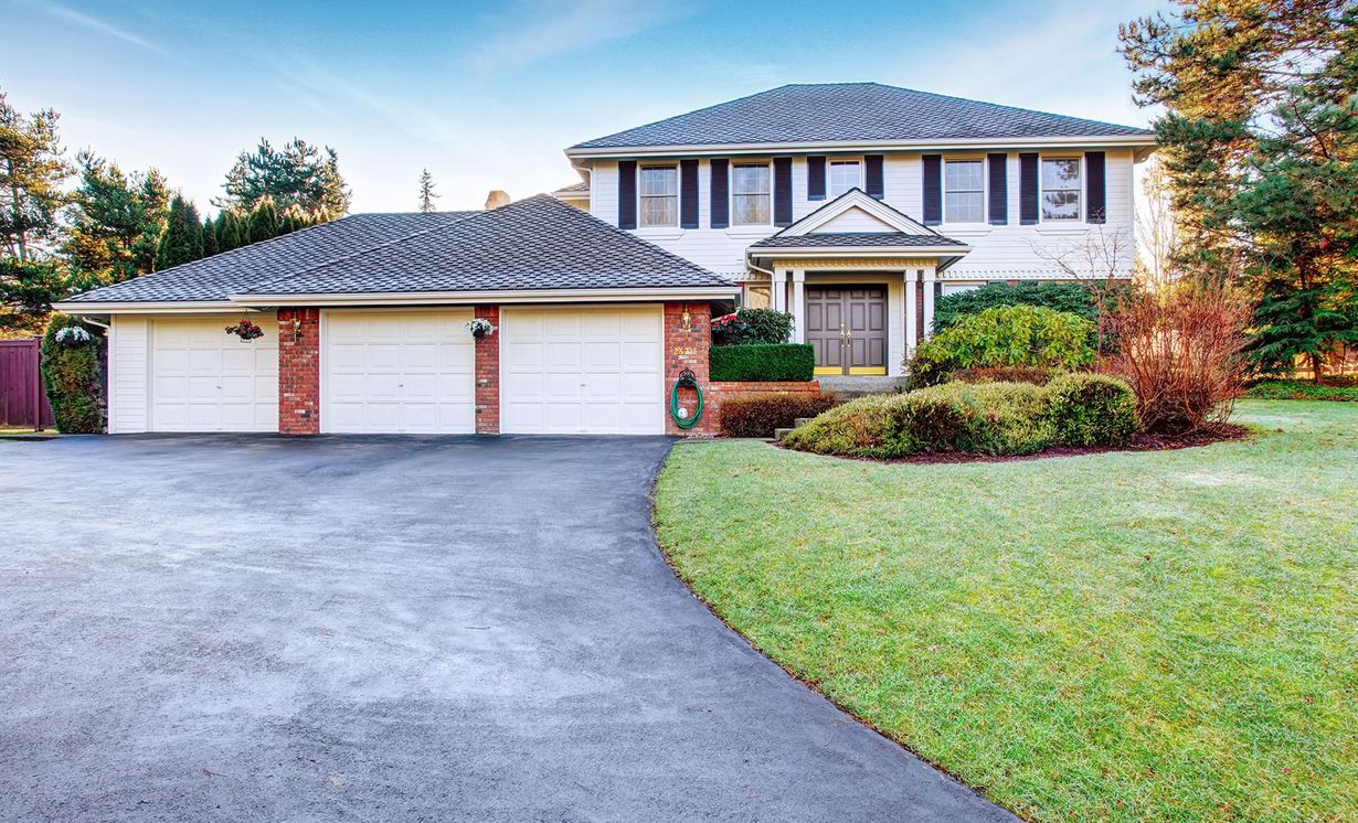A large house with three garage doors and a driveway