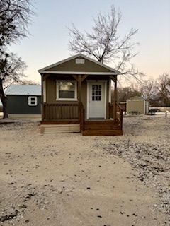 A small house with a porch and stairs 