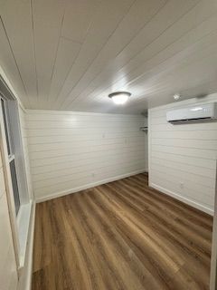 An empty room with hardwood floors and white walls