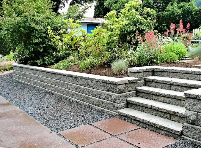 Stone retaining wall with steps and a planted garden.