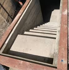 Concrete staircase leading down, framed by wood.