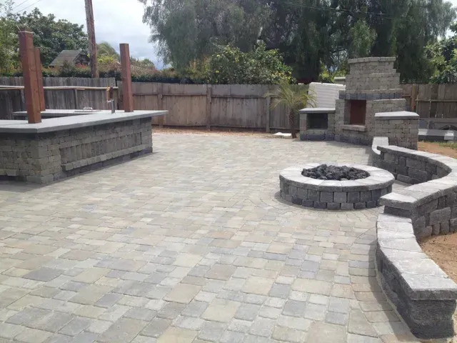 Outdoor patio with a built-in bar, fireplace, fire pit, and stone retaining walls.