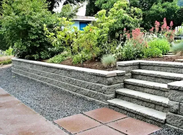 Stone retaining wall with steps and a planted garden.