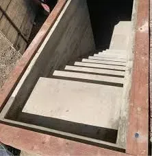 Concrete staircase leading down, framed by wood.