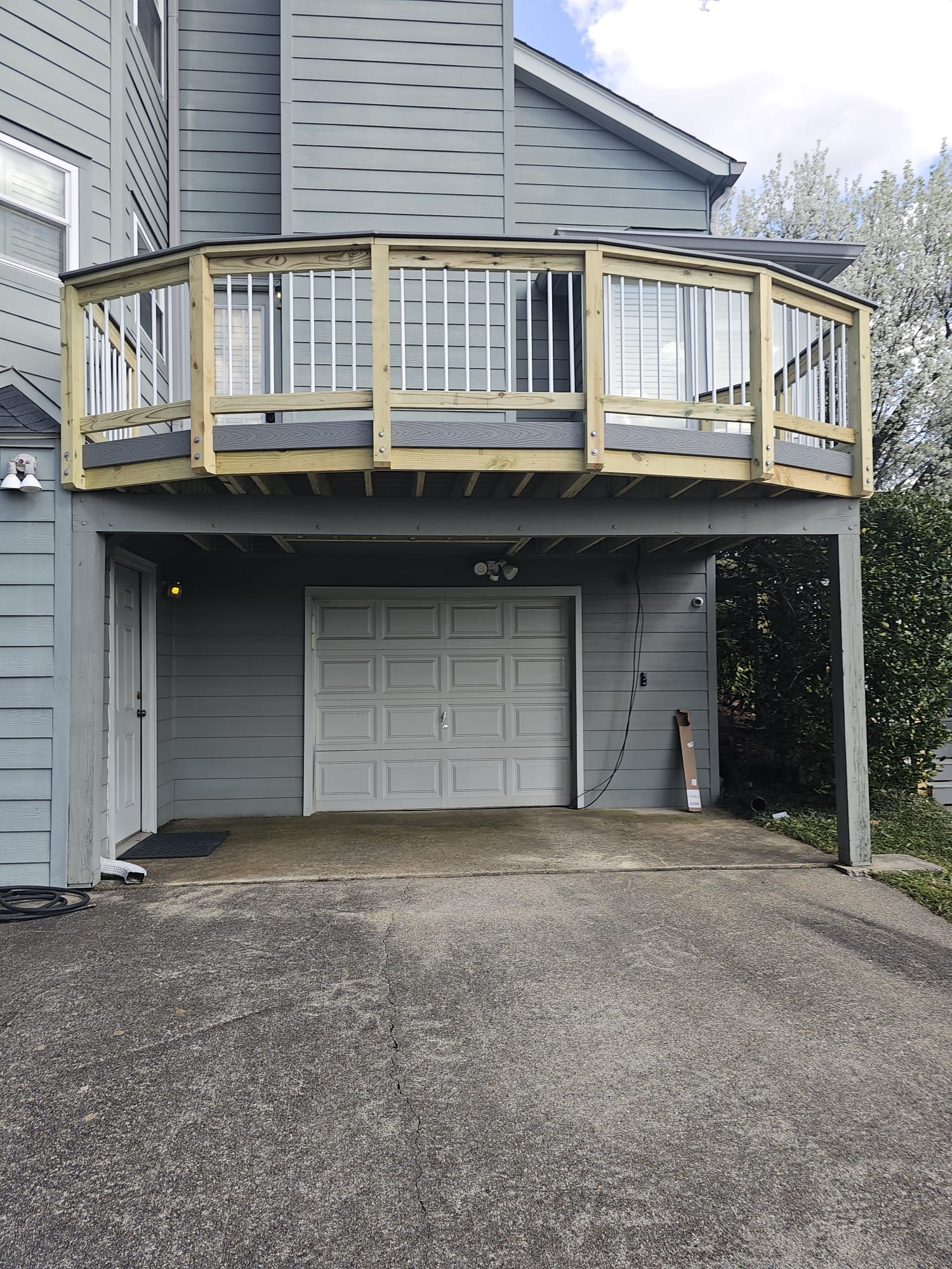 A house with a wooden deck over a garage door.