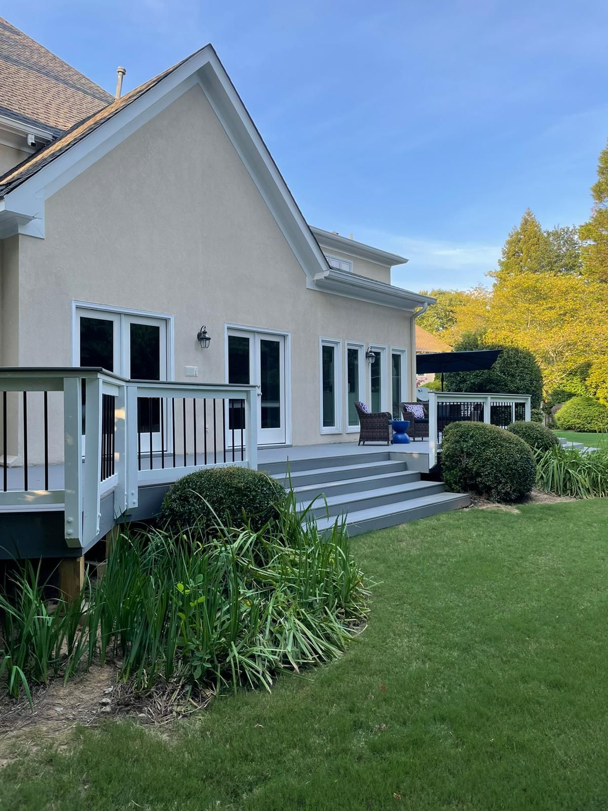 A large house with a deck and stairs in the backyard.