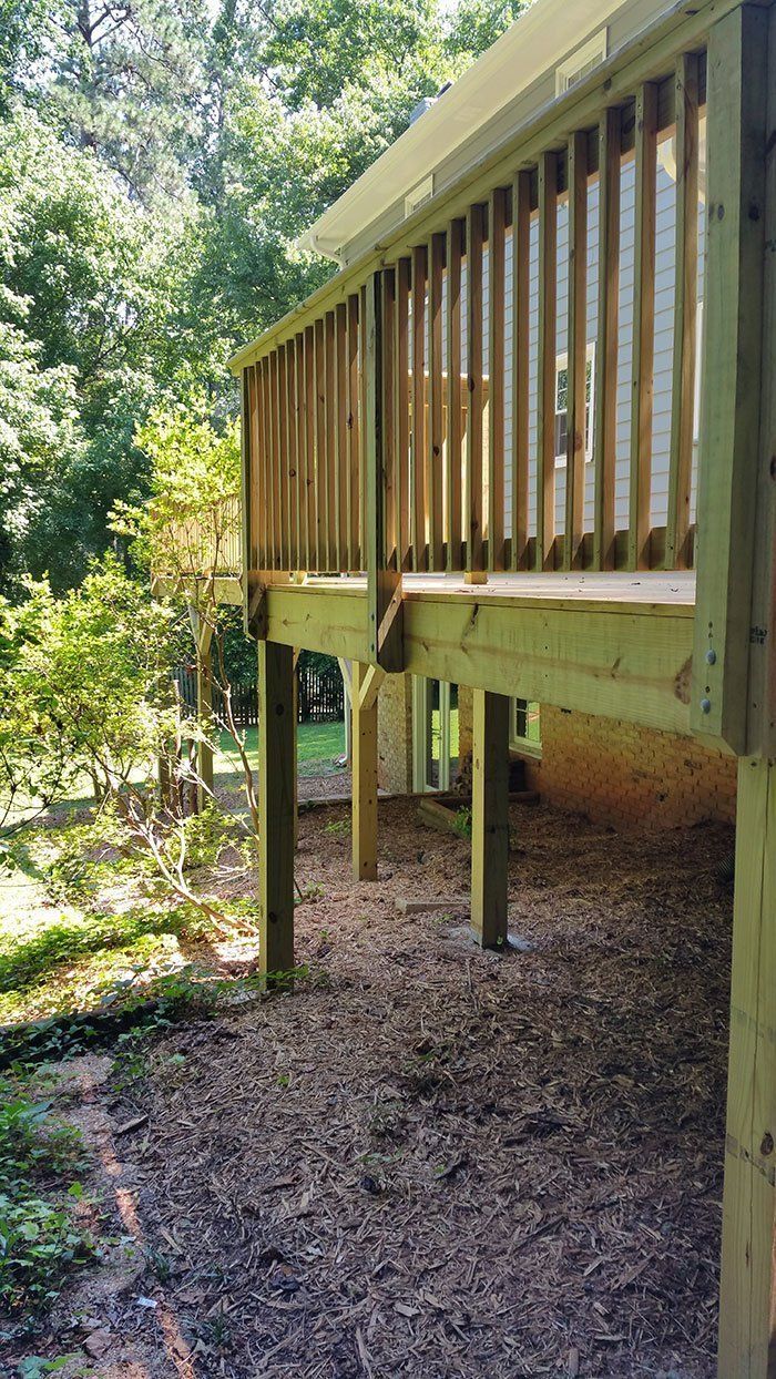 A wooden deck is being built in the backyard of a house.