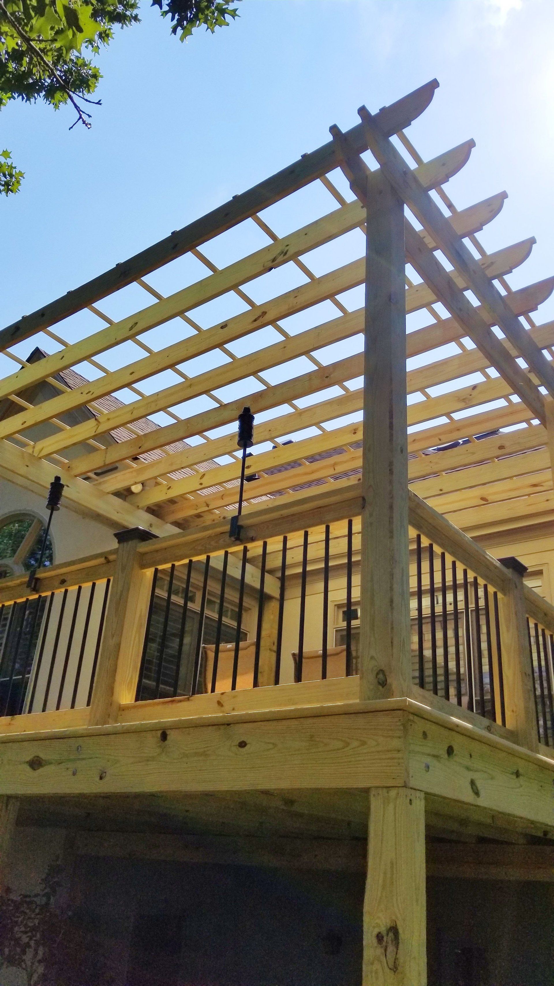 A wooden deck with a pergola on top of it