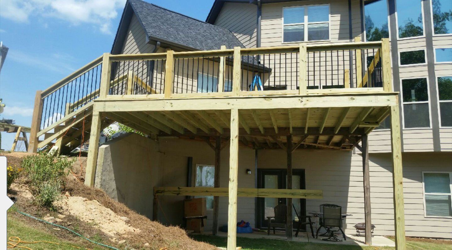 A large house with a wooden deck in front of it.