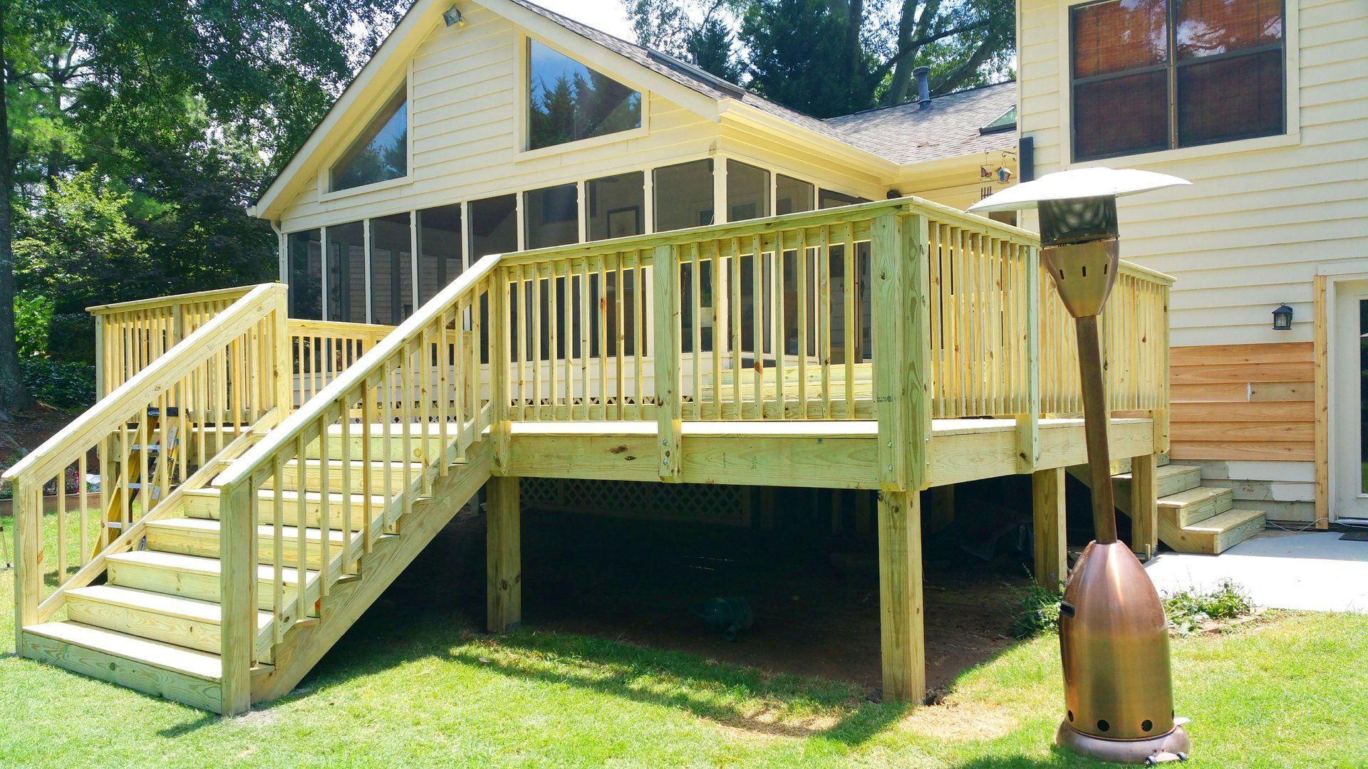 A house with a screened in porch and a wooden deck