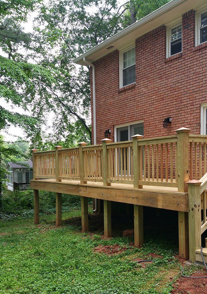 A brick house with a wooden deck in front of it.