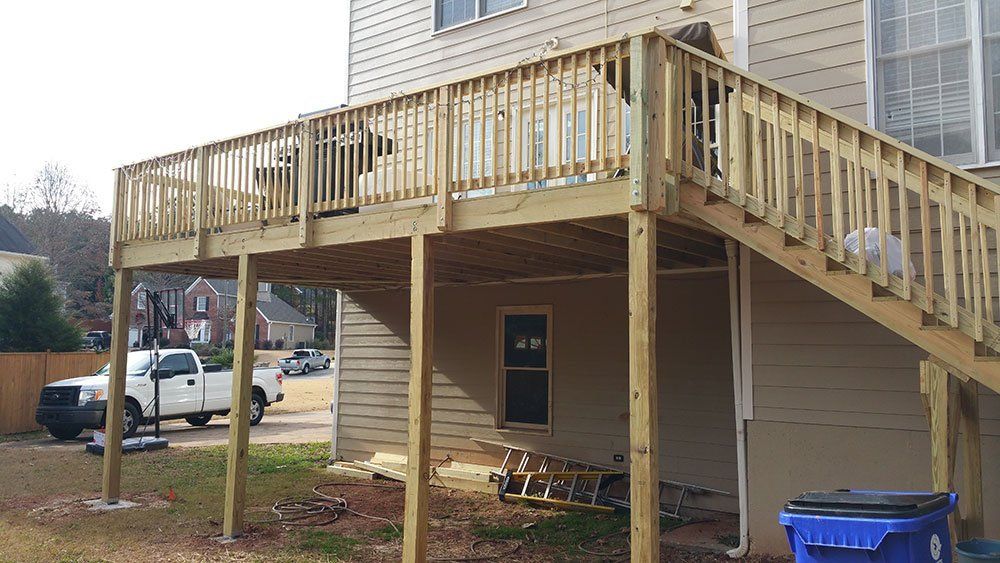 A wooden deck is being built on the side of a house.