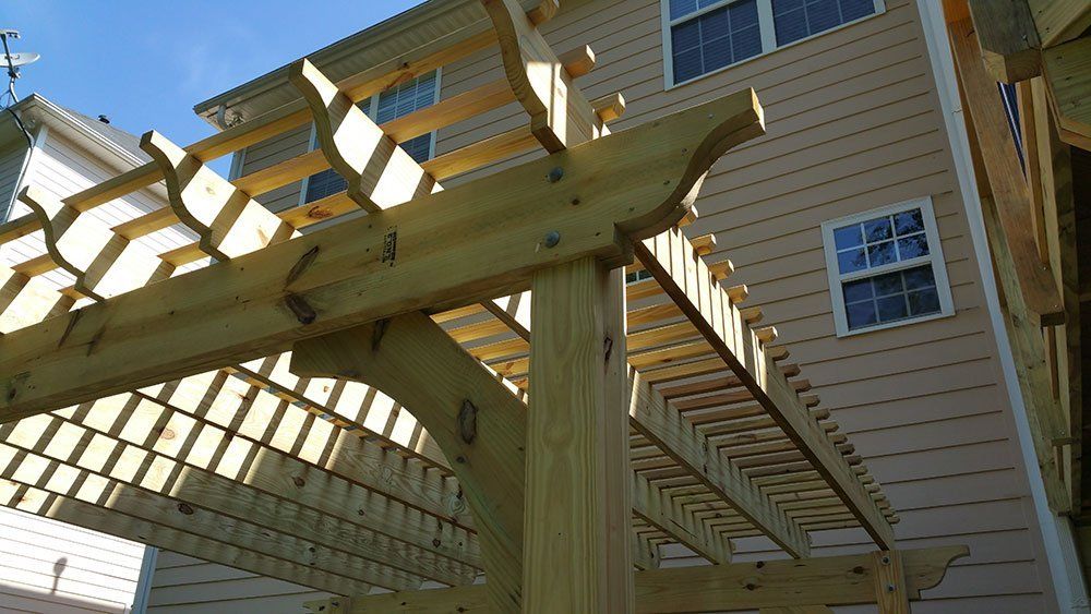 A wooden pergola is being built in front of a house