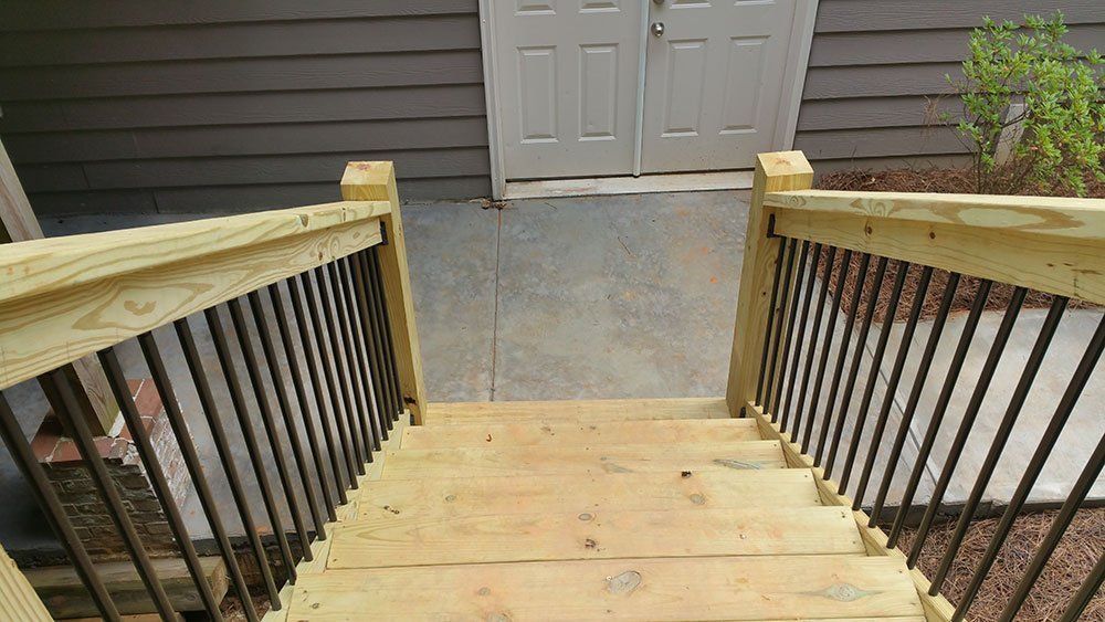 A wooden deck with stairs leading up to a house.