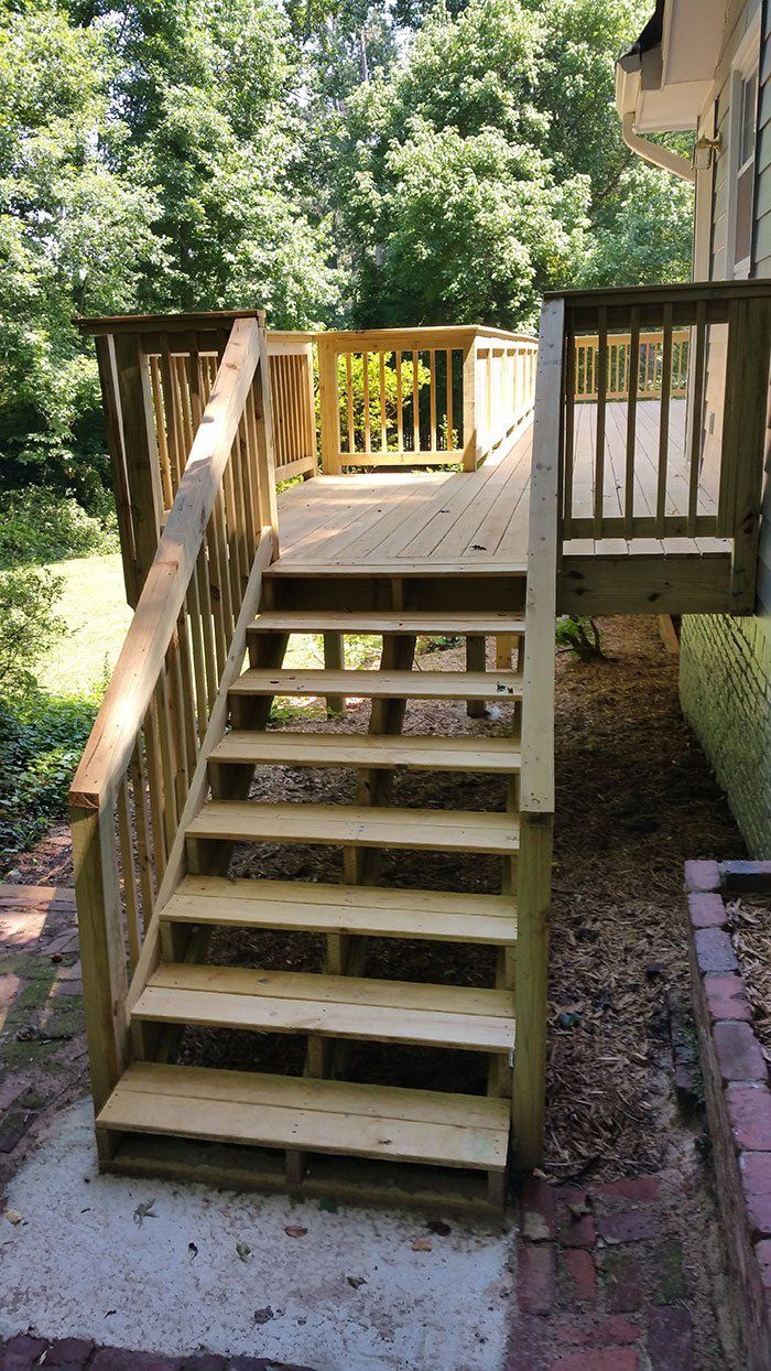 A good-looking wooden deck with stairs leading up to it.