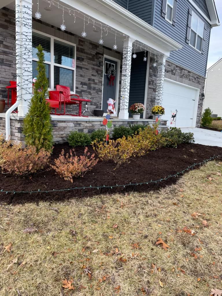 A house with a porch and a garden in front of it.