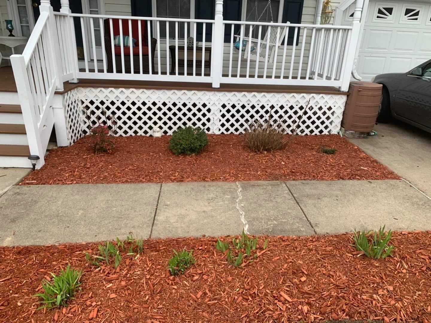 A house with a porch and a car parked in front of it.
