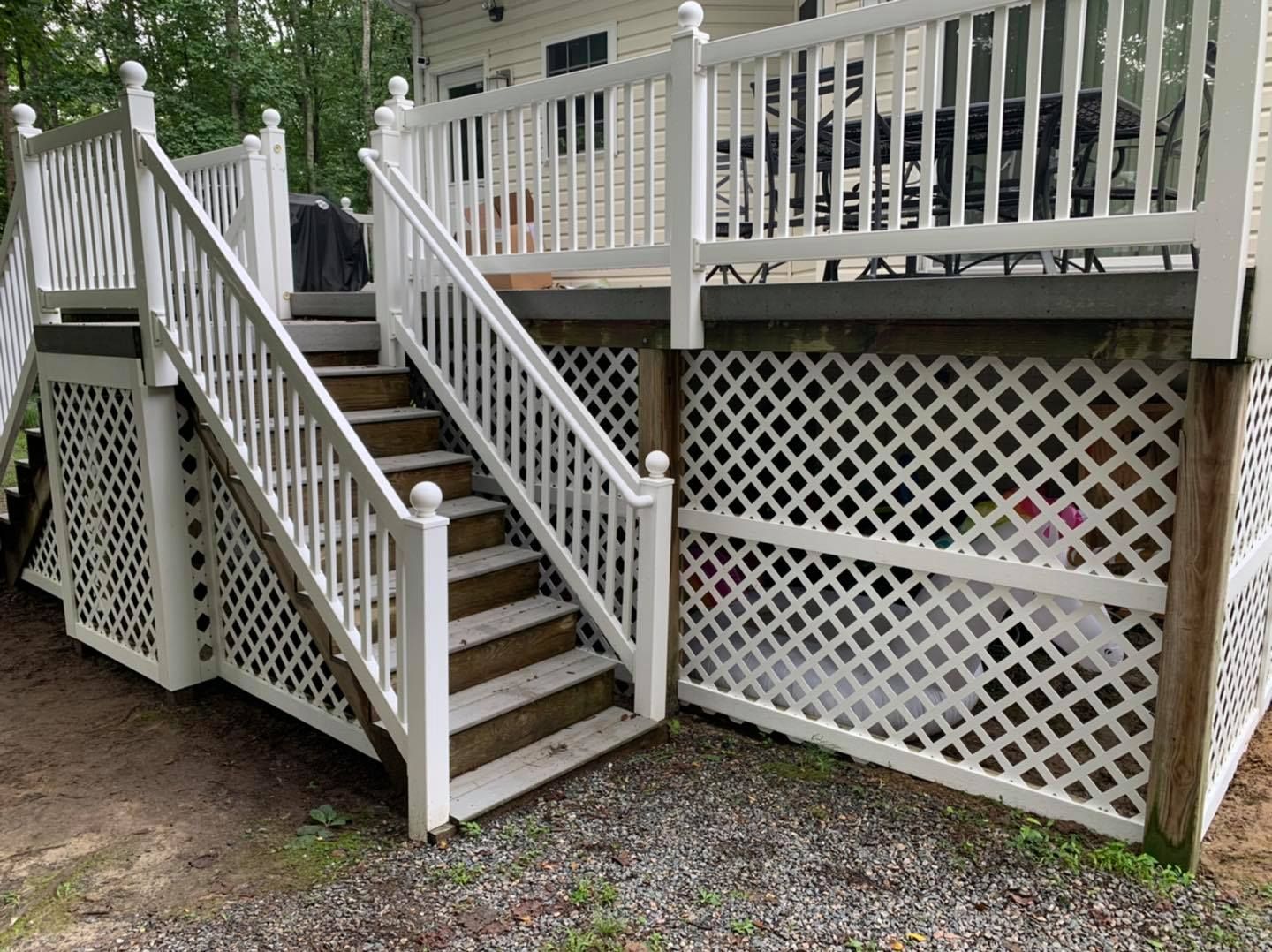 A white deck with stairs leading up to it.