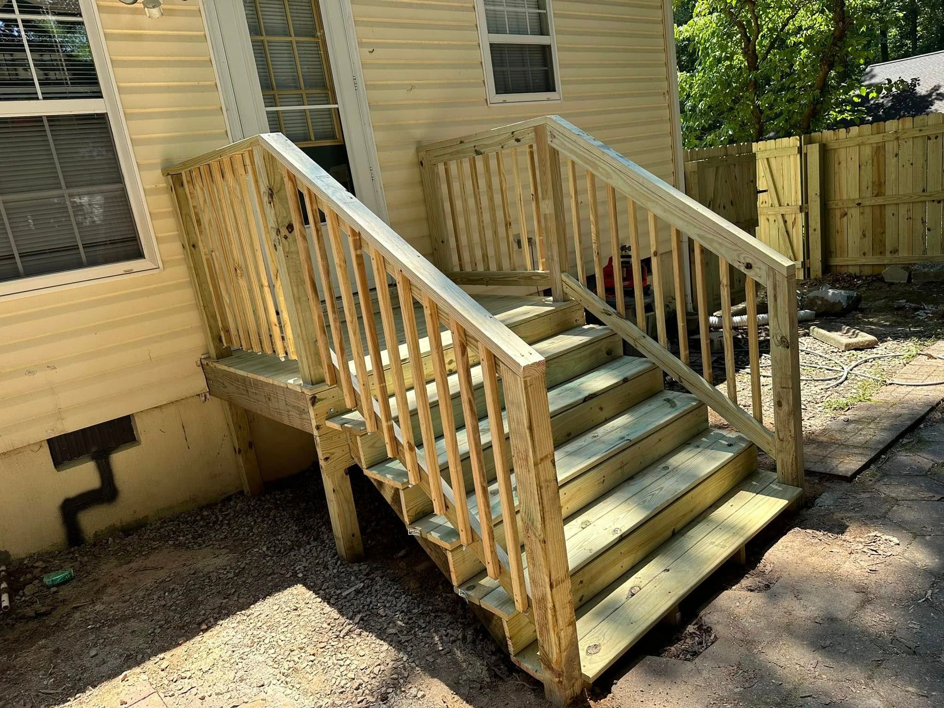 A wooden deck with stairs leading up to a house.