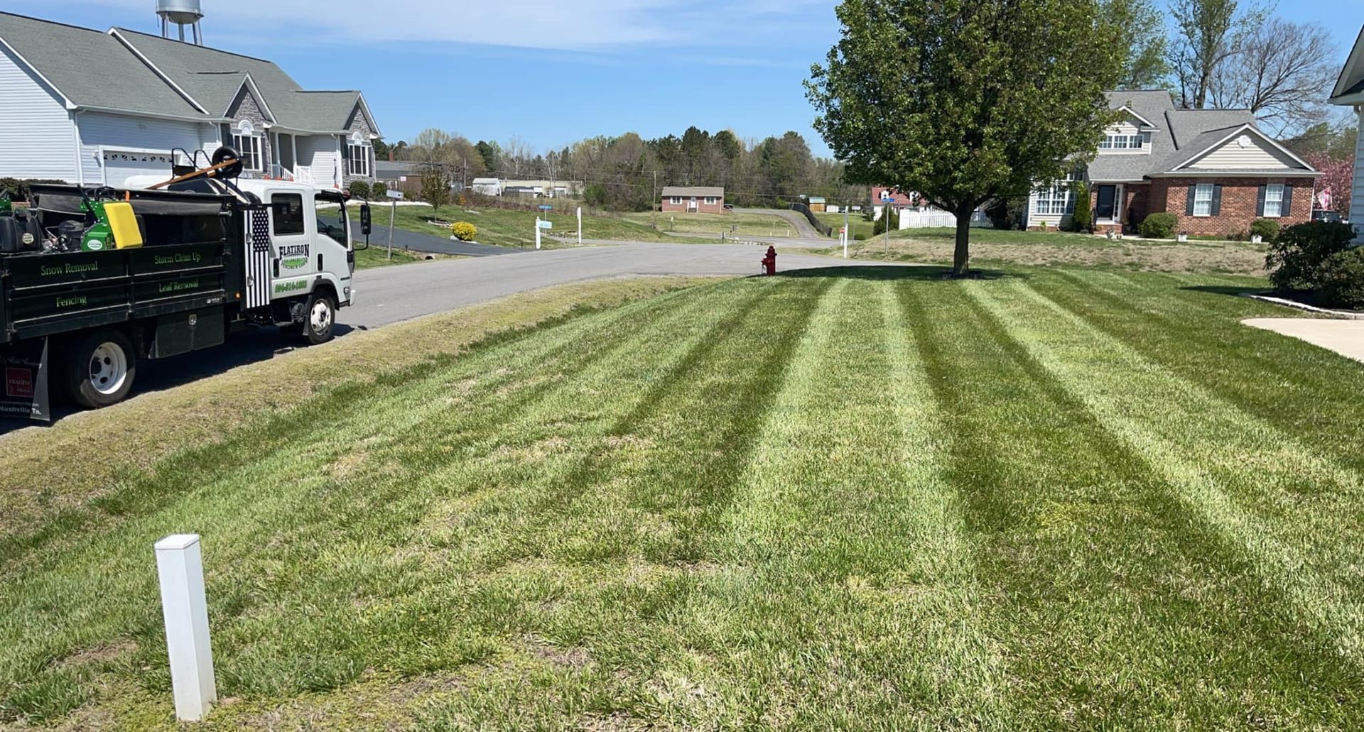A truck is parked in front of a lush green lawn.