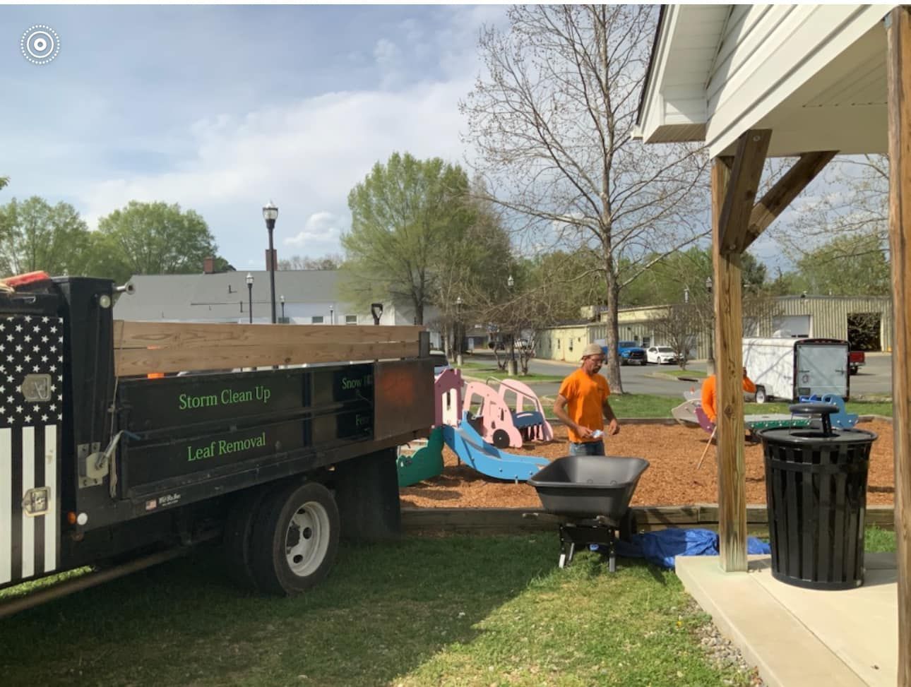 A dump truck is parked in front of a playground.