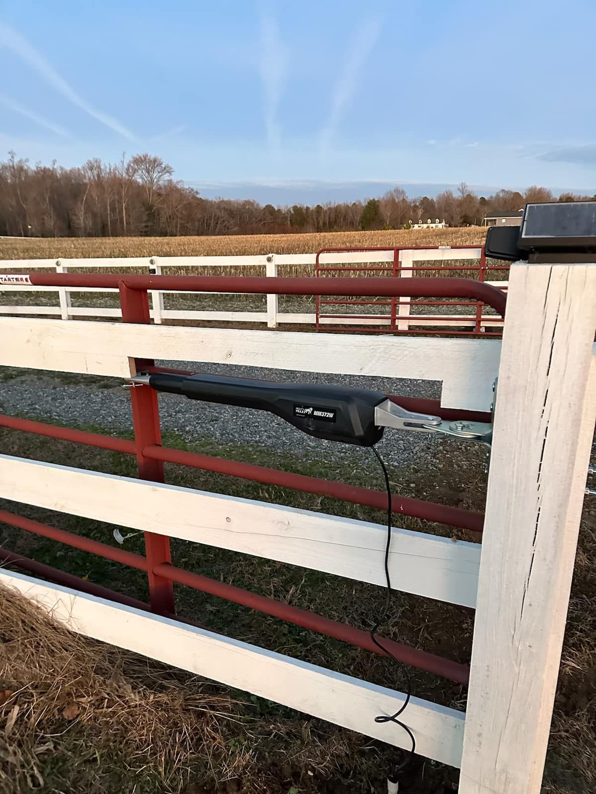 A white and red fence with a motor attached to it.