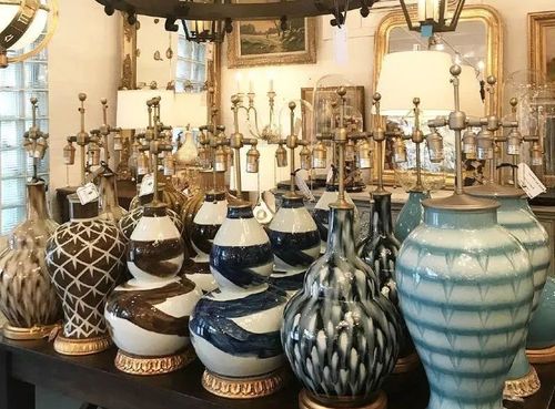 Assorted decorative glass vases with blue, brown, and white patterns displayed on shelves in a shop