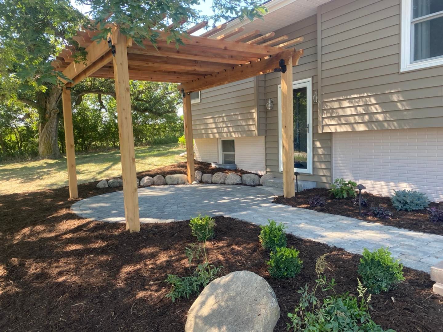 A house with a pergola and a walkway in front of it.