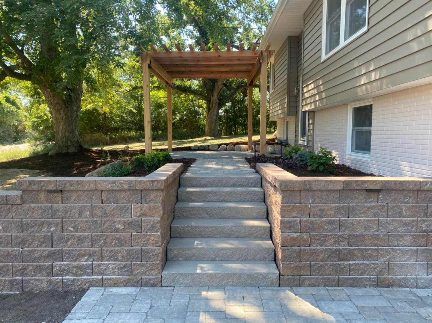 A house with a pergola and stairs leading up to it.