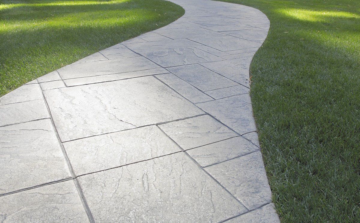 Stone pathway winding through green grass.