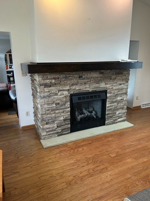 A living room with a fireplace and a wooden floor.