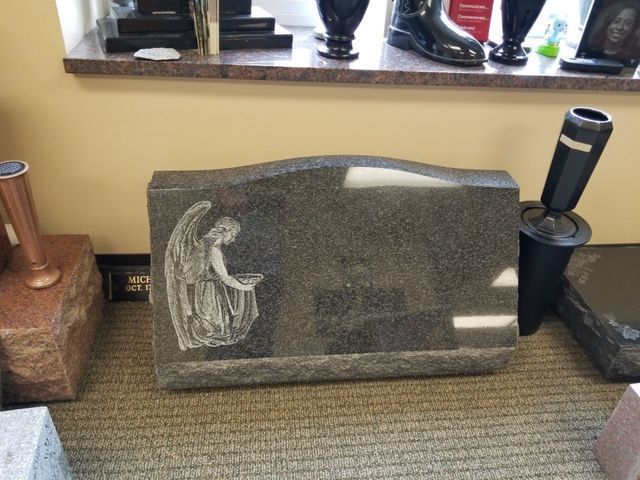 A gravestone with a picture of an angel on it