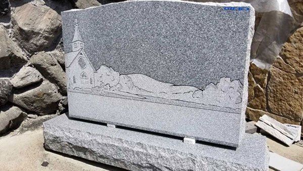 A gravestone with a picture of a church on it.