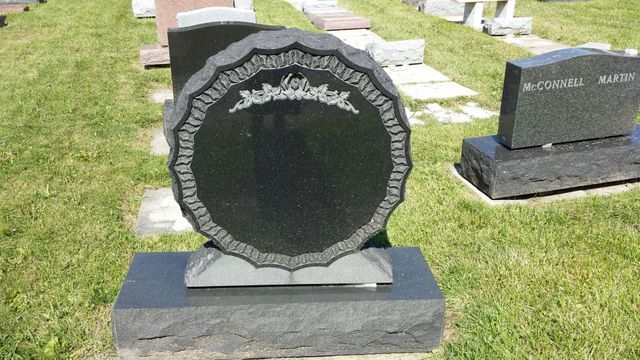 A gravestone in a cemetery with a circle in the middle