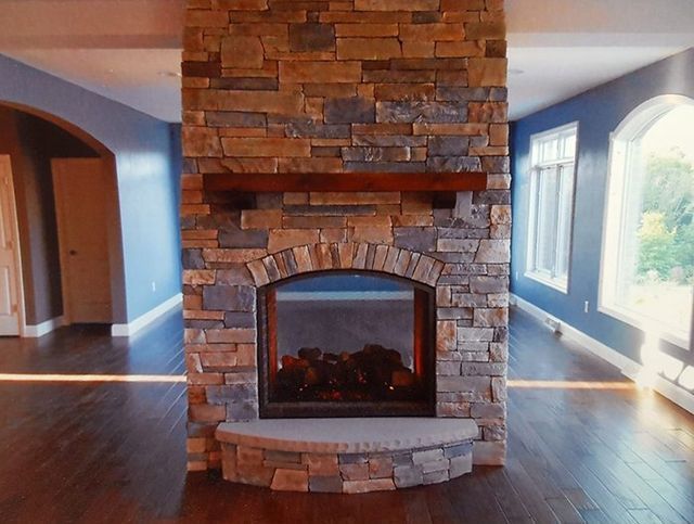 A stone fireplace in an empty room with blue walls