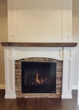 A living room with a fireplace and a mantle.