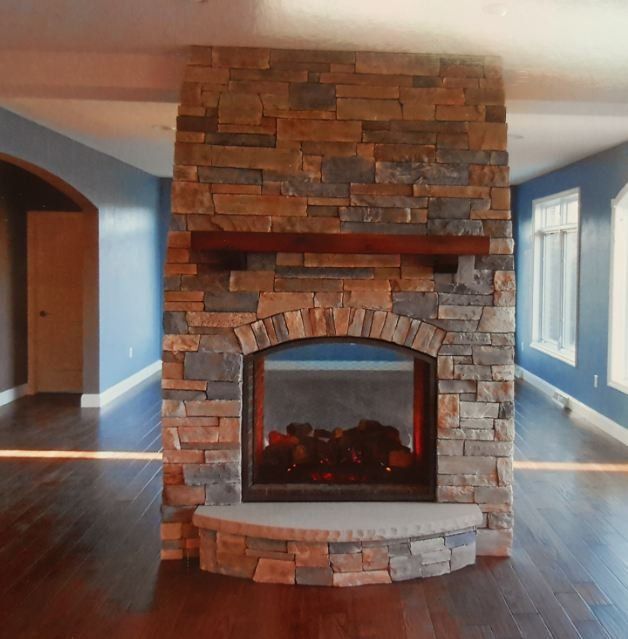 A large stone fireplace in an empty room